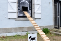 Michel François, Niche (La Ricarda), 2007, affiche adaptée par David Michael Clarke par l’ajout de deux rampes et d’un percement prévus pour la circulation des chiens. 2014. Vue de l'exposition: Flying Black Cow Utopia Club. Galérie du Dourven. Trédez-Locquémeau. 2014. Photo: Hervé Beurel.